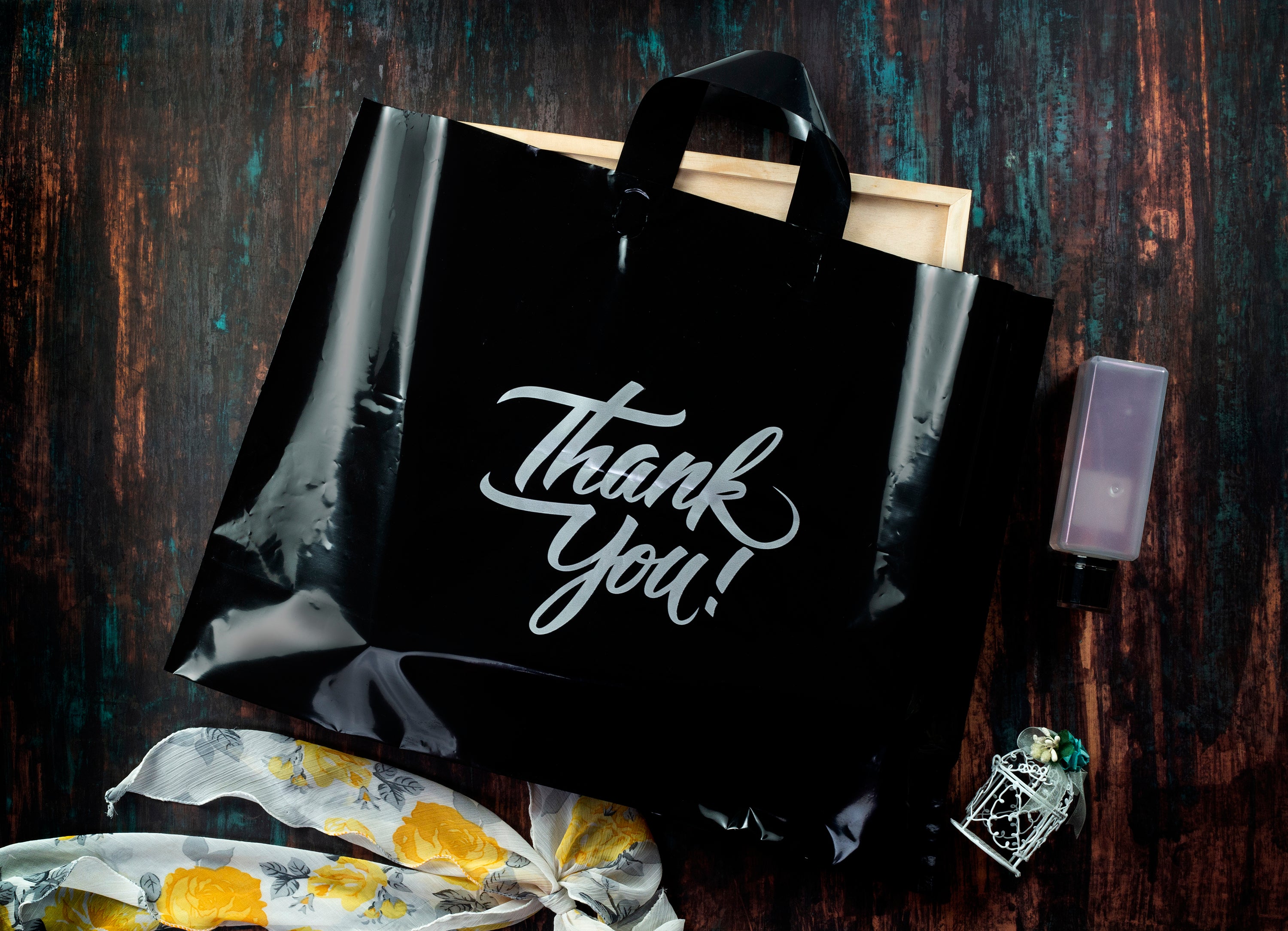 real life image of black thank you bag with object inside
